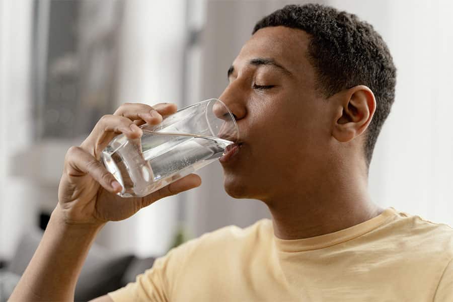Young man drinking water concept image for taking in medicines for detoxification.
