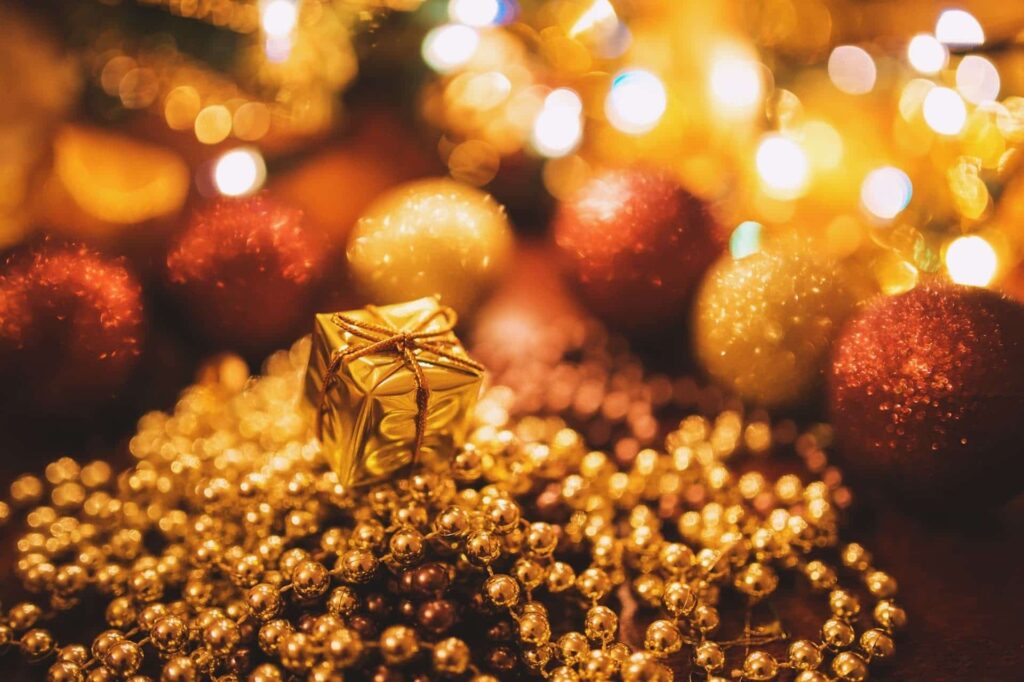 a gold wrapped present on a beaded garland