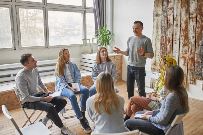 man in group therapy telling story about his recovery from stimulant addiction,