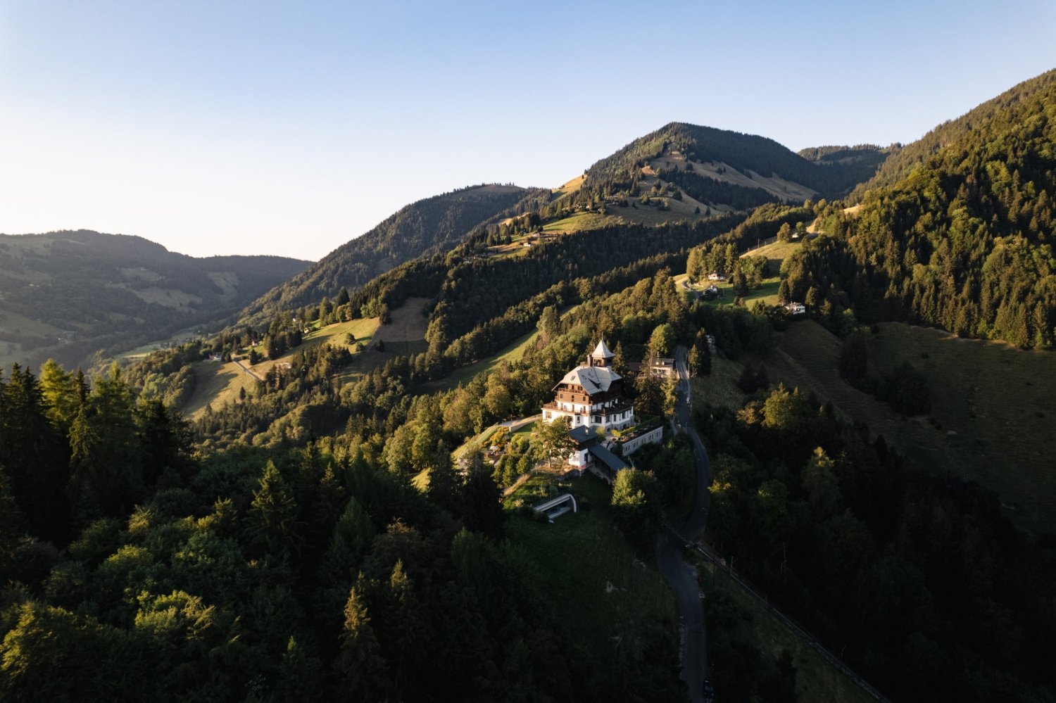 Aerial photo of the Clinic Les Alpes Facility amidst forested hills