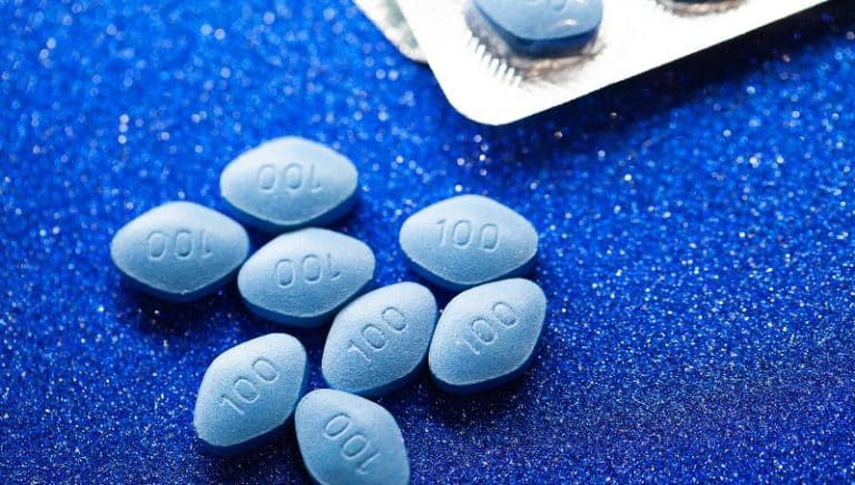 Blue diamond shaped 100 mg viagra pills on a blue table